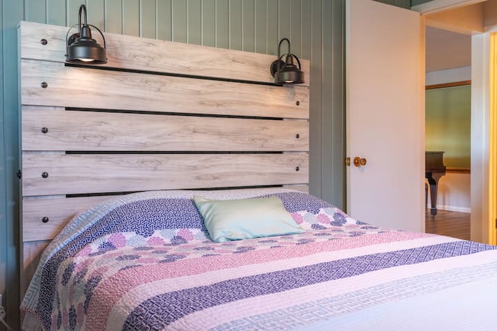 Spálňa s manželskou posteľou, televízor a stropný ventilátor