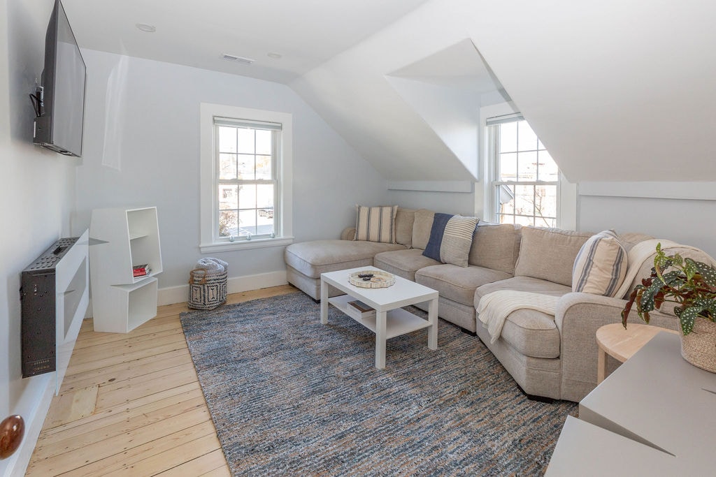 High Tide living room with comfy sectional, 50" smart Roku television, modern electric fireplace, games, puzzles and books!  Black out shades for the afternoon nap.