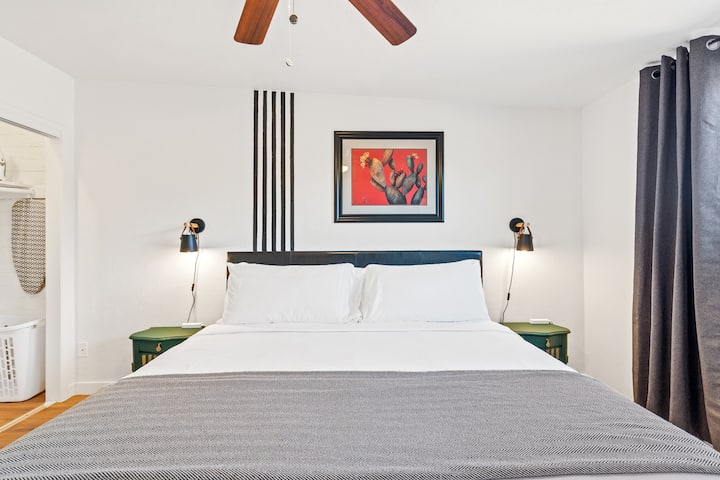Primary bedroom features a king size bed, blackout curtains, a smart TV, on suite bathroom, reading lamps, nightstands with USB plugs for easy access, and mirrored closet doors just to name a few!