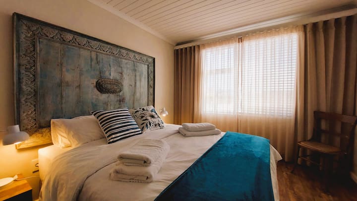 Chambre principale avec lit Queen Size et belle tête de lit indonésienne. Matelas, oreillers, couette et linge de lit de haute qualité sont fournis pour une bonne nuit de sommeil. 