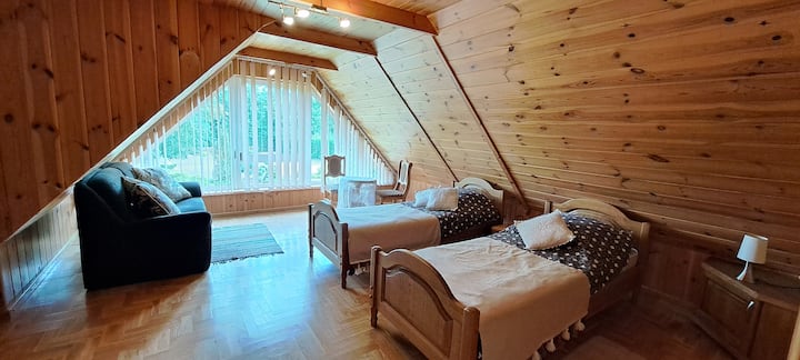 سريران مفردان وغرفة أريكة تطل على الحديقة.