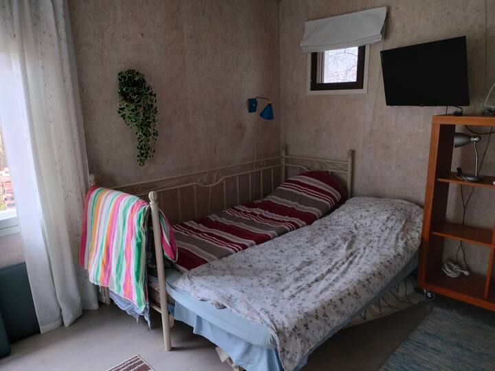 Katika chumba cha meko cha sauna ya uani kuna kitanda maradufu na runinga.