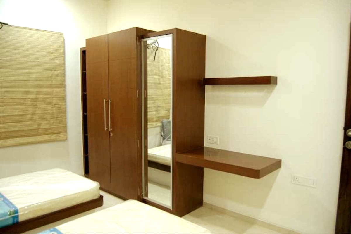 3e slaapkamer met 2 eenpersoonsbedden en kasten en een eigen badkamer met een douche.