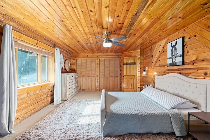 غرفة نوم رئيسية بإطلالات خارجية وسجادة مريحة وحمام خاص.