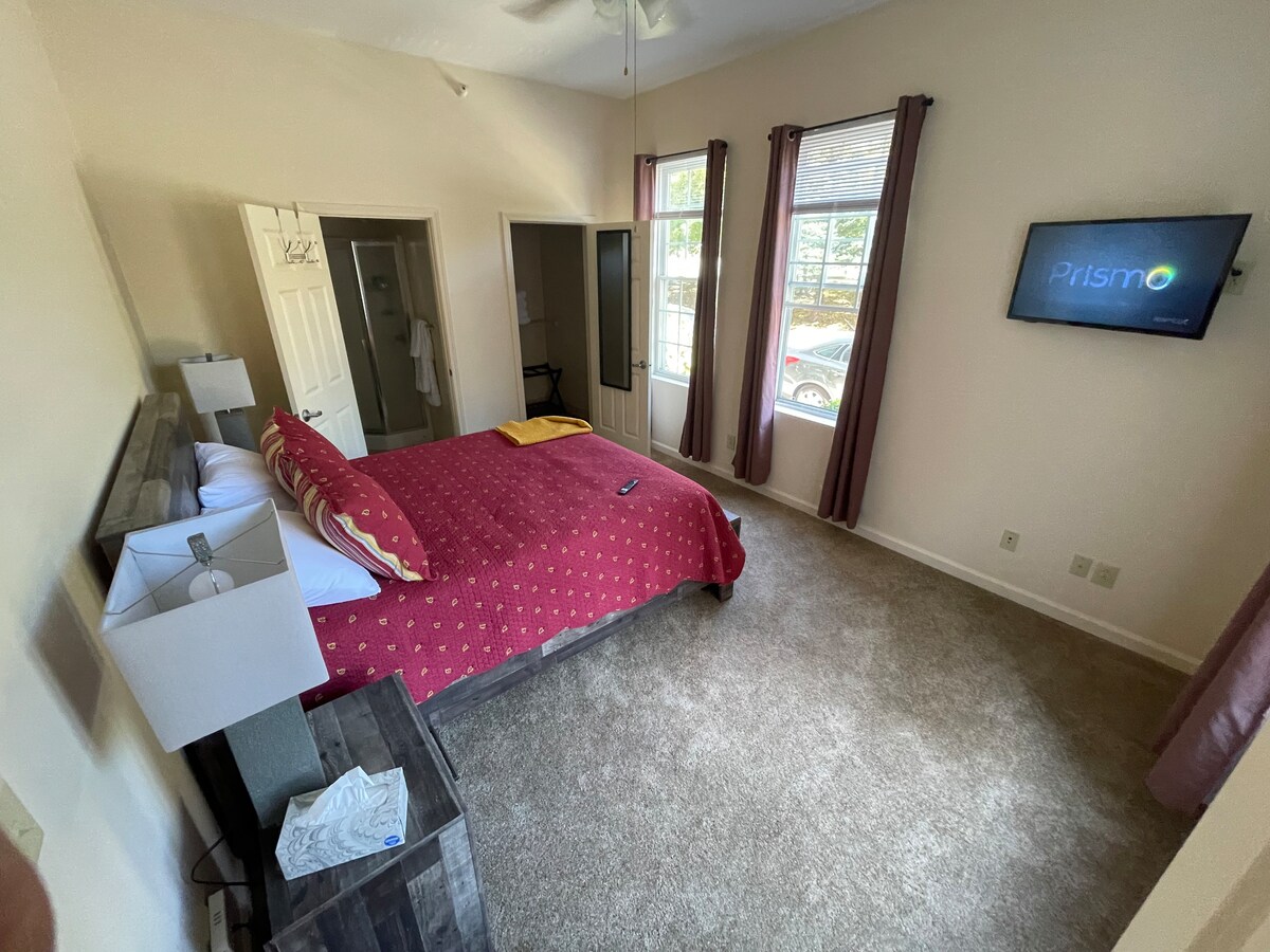 Schlafzimmer #3 Hauptschlafzimmer verfügt über ein Queensize-Bett, Fernseher, Verdunkelungsvorhänge und eine Ladestation für Elektronik.