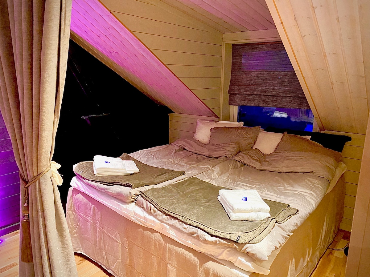 Krásna veľká manželská posteľ King (180 cm) s výhľadom na otvorené pole dole k fjordu. Tu sa prebúdzate osviežení.