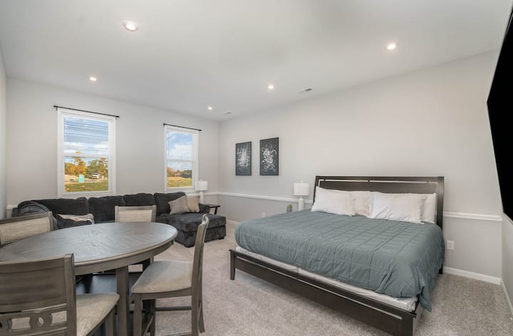 Оваа брачна спална соба на вториот кат има дополнителен простор за дружење со места за седење и телевизор со рамен екран.