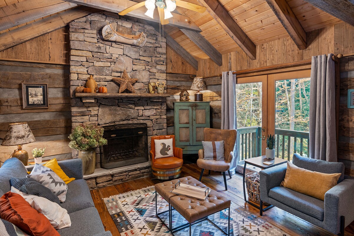 Reclaimed timbers from 19th century Virginia barns were used to construct the 30-year-old cabin. Rustic furnishings include antique whiskey barrel chairs and antique pie safe. 