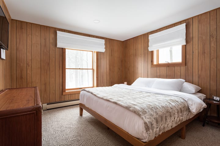Dormitorio del primer piso con cama king size y televisor inteligente