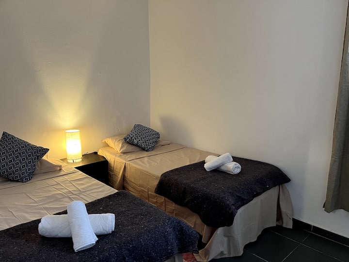 Spálňa na druhom poschodí s prenosným ventilátorom.