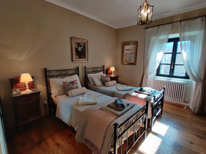 غرفة النوم 1، "Vis e Vin" أو الكرمة والنبيذ بلهجة Piedmontese.
يمكن أن يصبح السريران التوأم سريرًا بحجم كينغ مقسم.