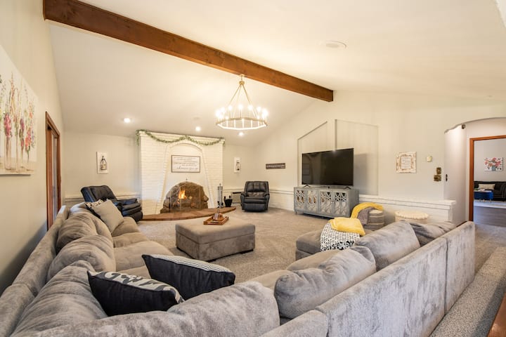 The cozy grand family room features a  75" TV, wood-burning fireplace and seating for 16. Sink down into the cozy cloud couch for movie night with the whole family.