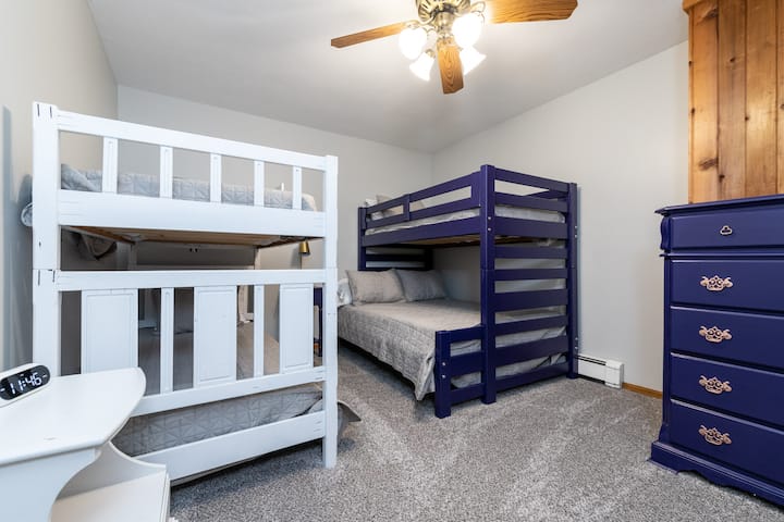 Basement bedroom with two bunk beds including 3 twins and one full size bed.