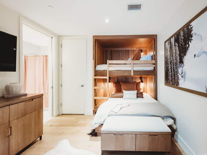 Queensize bed met twee eenpersoonsbedden erboven. Eigen badkamer met bad