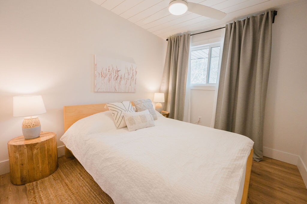 Spálňa na hornom poschodí s manželskou posteľou a stropným ventilátorom.