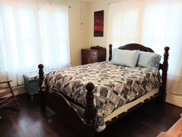 Dormitorio tamaño queen en la parte delantera de la casa, con armario, vestidor, cómoda y mecedora. Actualmente tiene TCL 4K Roku TV.