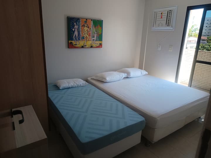 ห้องนอน 1 - เตียงควีนไซส์เตียงเดี่ยวหมอนตู้เสื้อผ้าเครื่องปรับอากาศพัดลมเพดานระเบียงด้านข้าง