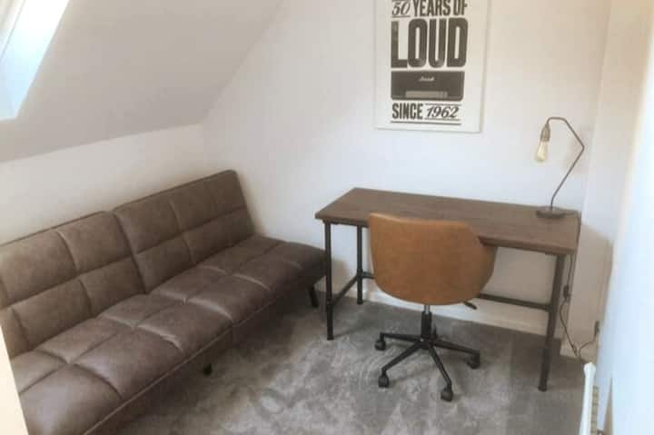 Segundo dormitorio o estudio, con cama individual grande, plegable, sofá cama, escritorio y silla de oficina.