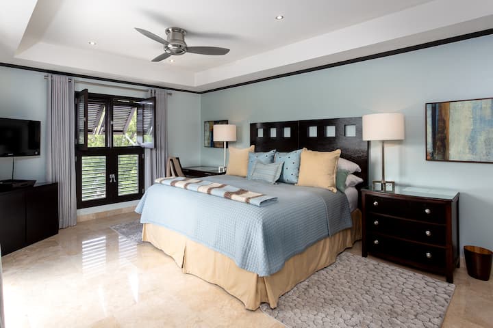 Magaan at maaliwalas na silid - tulugan na may king size na higaan sa UK, air conditioning, ceiling fan, TV, at en suite na shower room.