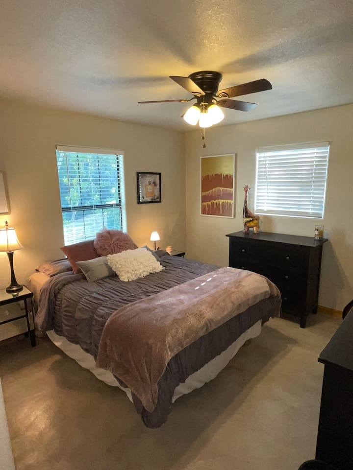 1 of 2 downstairs bedrooms has a warm, modern feel and a comfy queen bed. There is a TV with Roku (for signing into any of your streaming subscriptions), in case you want to hide away and enjoy a show. 