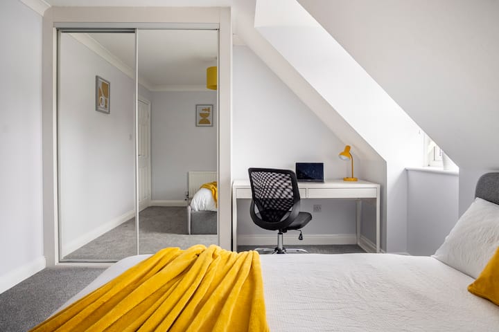 Slaapkamer 3 (de gele kamer) met groot tweepersoonsbed, bureau en ingebouwde kledingkast 