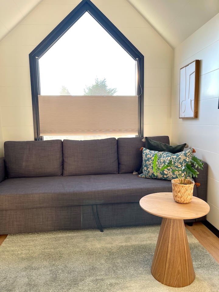 סלון שטוף שמש עם ספה נפתחת לשני אנשים