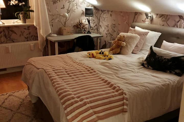 Dhomë gjumi në katin e sipërm me krevat dopio 160 cm të gjerë dhe tavolinë më të vogël.