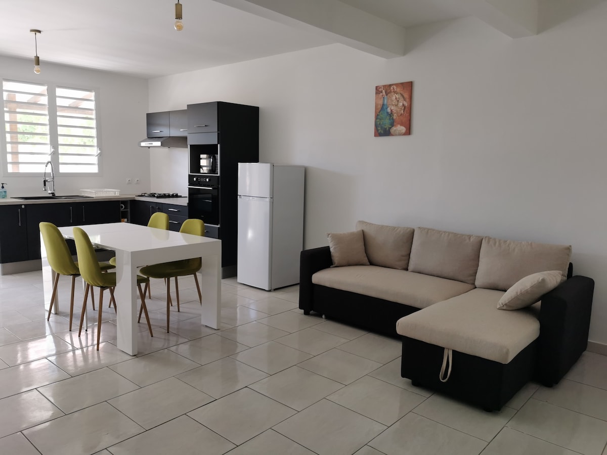 Sala de estar con gran sofá cama abierto a la cocina equipada 