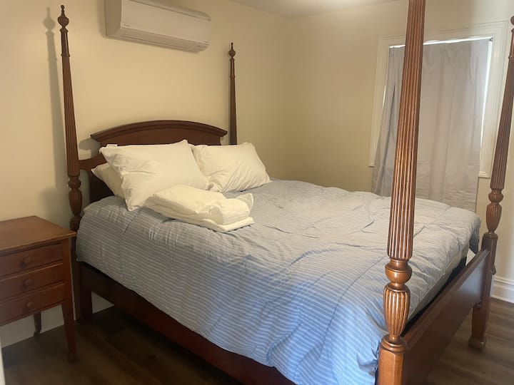 Cama tamaño queen en el nivel principal junto a la sala de estar y la cocina