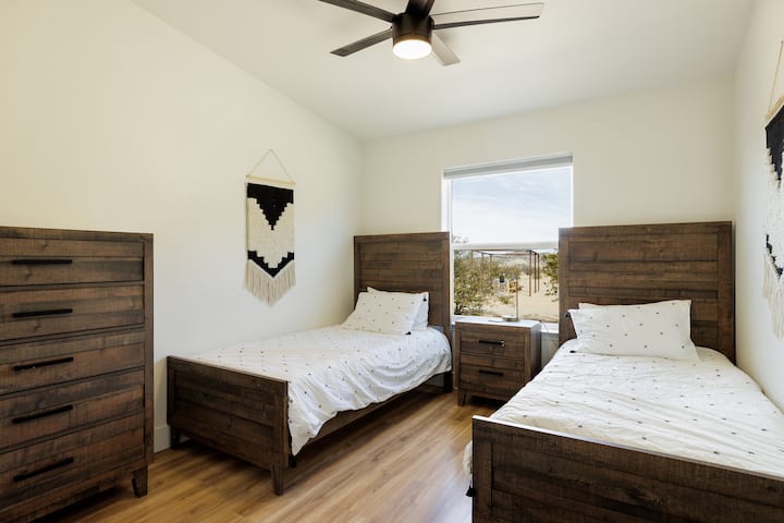 Deux lits jumeaux avec une literie confortable et une vue magnifique sur le désert. 