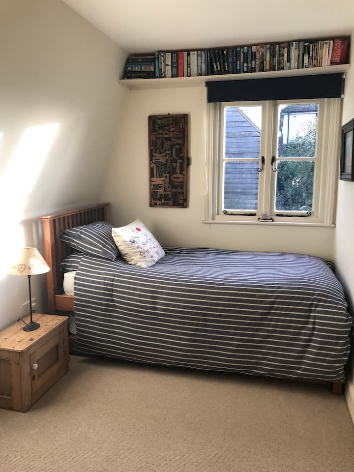 غرفة فردية صغيرة مع خزانة ملابس ورفوف مدمجة، وسرير صندوق واحد مع سرير فردي ثانٍ تحته - مناسب لطفلين أو شخصين بالغين لا يمانعان أن يكونا مرتاحين! 