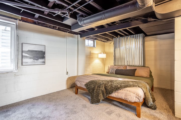 Unwind in the spacious downstairs bedroom with a king bed, full-length mirror, and TV. The connected lounge area makes it a cozy, private retreat for relaxing after a day of exploring.