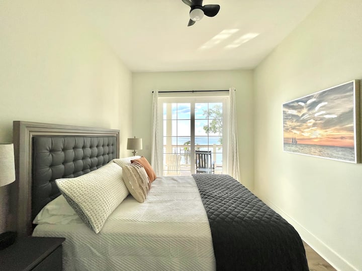 La suite Sunset tiene una cama tamaño queen y acceso privado al porche trasero con increíbles vistas al atardecer sobre la bahía.