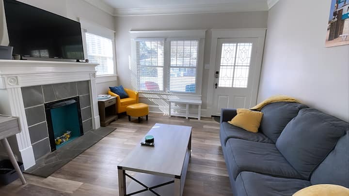 סלון עם ספה נוחה, טלוויזיה חכמה וכיסא קריאה.