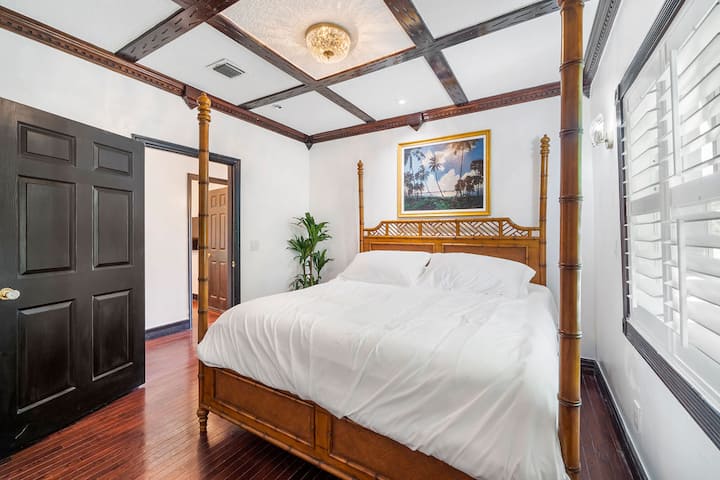 Seconda camera da letto con un grande letto king-size a baldacchino e dipinto di AE Backus, eminente paesaggista della Florida, di palme che dondolano nella brezza. C'è un museo a lui dedicato a Fort Pierce che vale il viaggio.