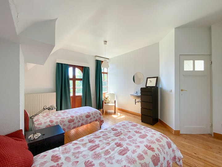 The green bedroom with two single beds and open view of the square.