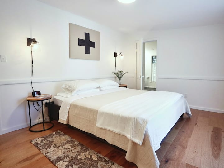 The main floor primary bedroom features a king sized bed, generous closets and an enormous bathroom including an oversized tub. A sliding glass door leads out to the backyard deck. 