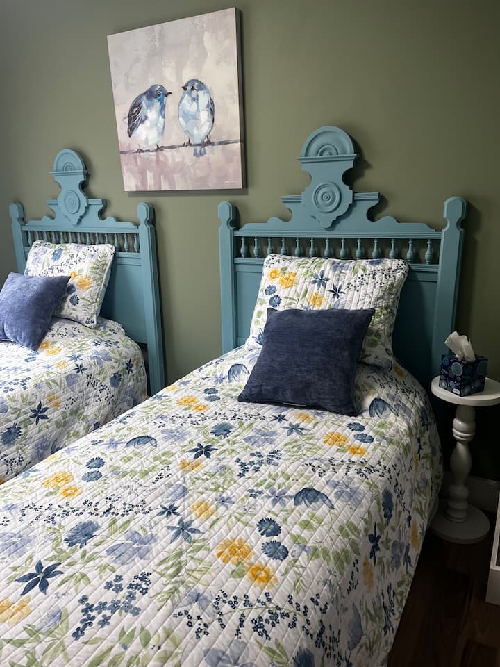 The second bedroom features twin beds, a reading nook, and a dual function closet or desk area, if you are working while away from home.