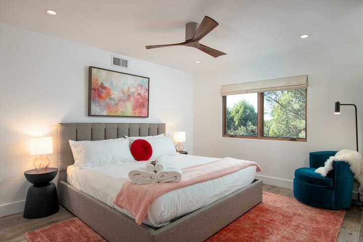 The second bedroom, located on the lower floor, also features a king-sized bed, a reading nook, and a window overlooking the wooded grounds