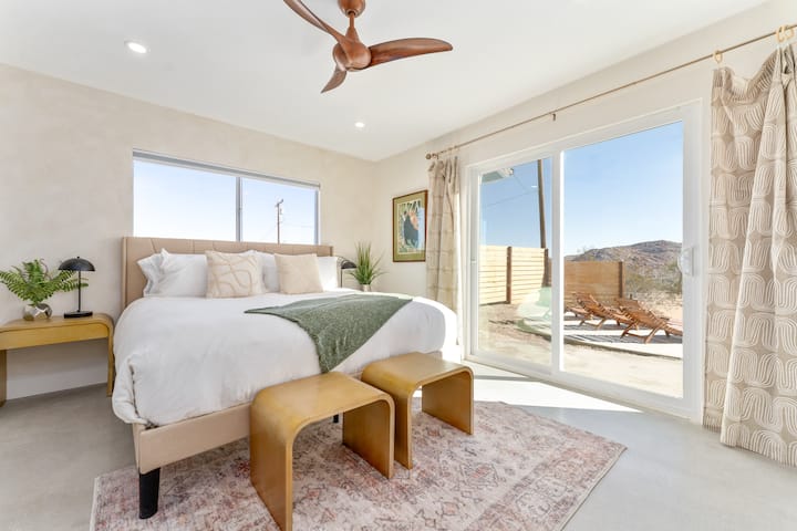غرفة نوم ثانية بها سرير كينج ومدخل إلى الفناء وديكور صحراوي أنيق