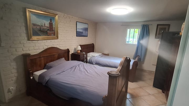 Amplia habitación con 4 camas en planta baja de jardín. Una de las camas individuales de esta foto es una pequeña cama doble de 120 cm de ancho.