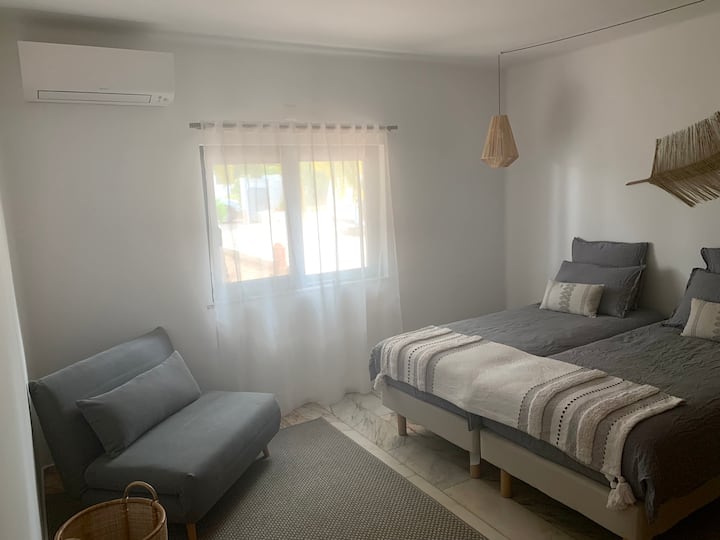 חדר שינה בקומת הקרקע, עם 2 מיטות יחיד וחדר רחצה