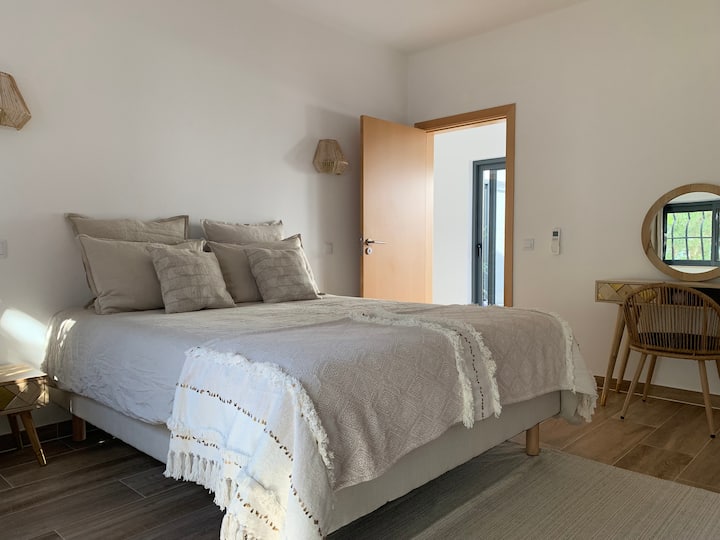 חדר שינה בקומת קרקע, עם מיטת קווין סייז, חדר הלבשה, פטיו פרטי וחדר רחצה