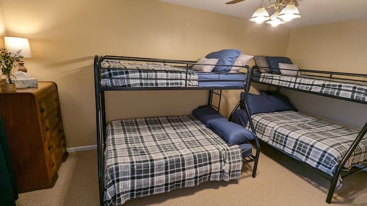 Upstairs bunk room featuring 2 bunk beds.  Each bunk bed has a full-size mattress on the bottom and a twin mattress on top.
