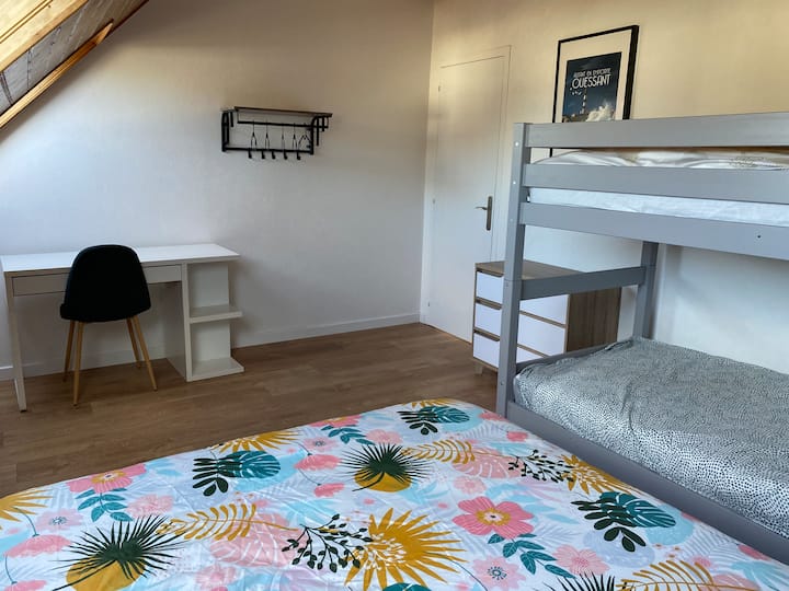 Det stora sovrummet på övervåningen med en dubbelsäng, våningssängar och ett skrivbord 