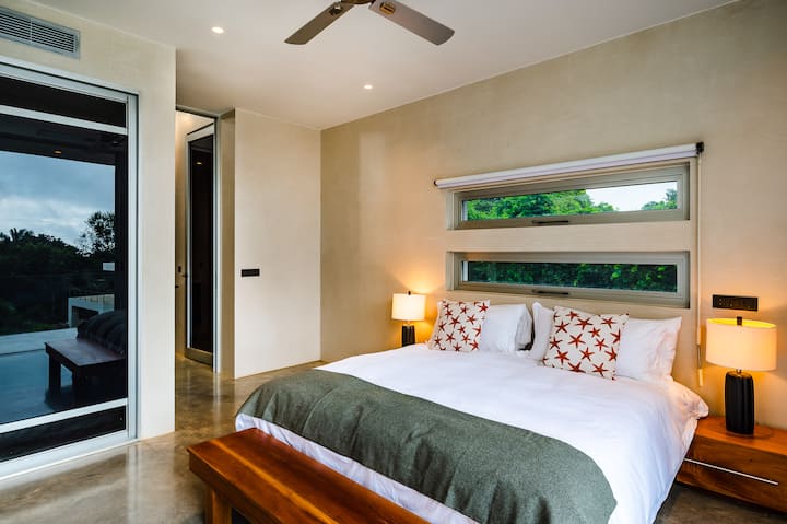 - Zakoračite u ovu svijetlu spavaću sobu s bračnim krevetom i plišanom posteljinom za ugodan boravak.
- Iz velikih prozora pruža se pogled na bujno zelenilo, upotpunjeno mekom ambijentalnom rasvjetom
- Elegantni ukrasi s prirodnim tonovima stvaraju mirnu i modernu atmosferu