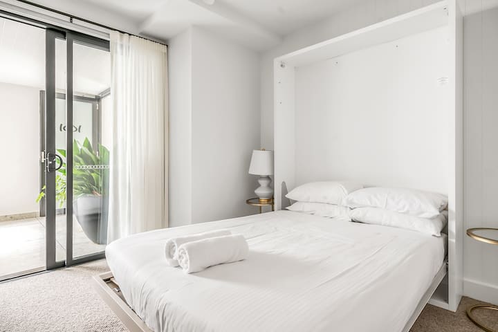 3rd bedroom with courtyard and Clei wall bed which doubles as a desk.