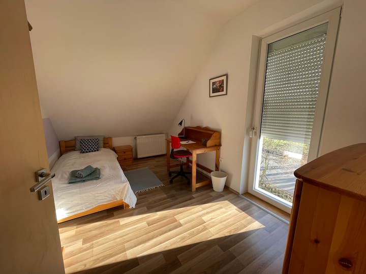 Simple bedroom with a workstation. 