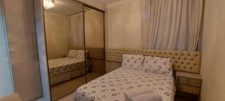 Suíte 1 com cama de casal. Guarda roupas modulado com espelho. Escrivaninha para trabalho. 
Ar condicionado. Cortina Black-out.
Roupa de cama e banho disponíveis (cortesia).
2 colchões de solteiro (extra) quando necessário.