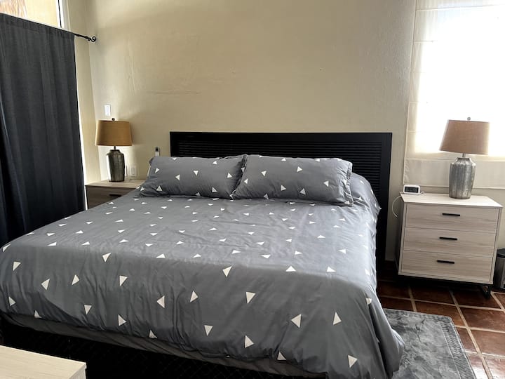 La chambre King s'ouvre sur le patio arrière, dispose d'une salle de bains privative, de beaucoup d'espace dans le placard, d'une commode, de la climatisation et de ventilateurs.